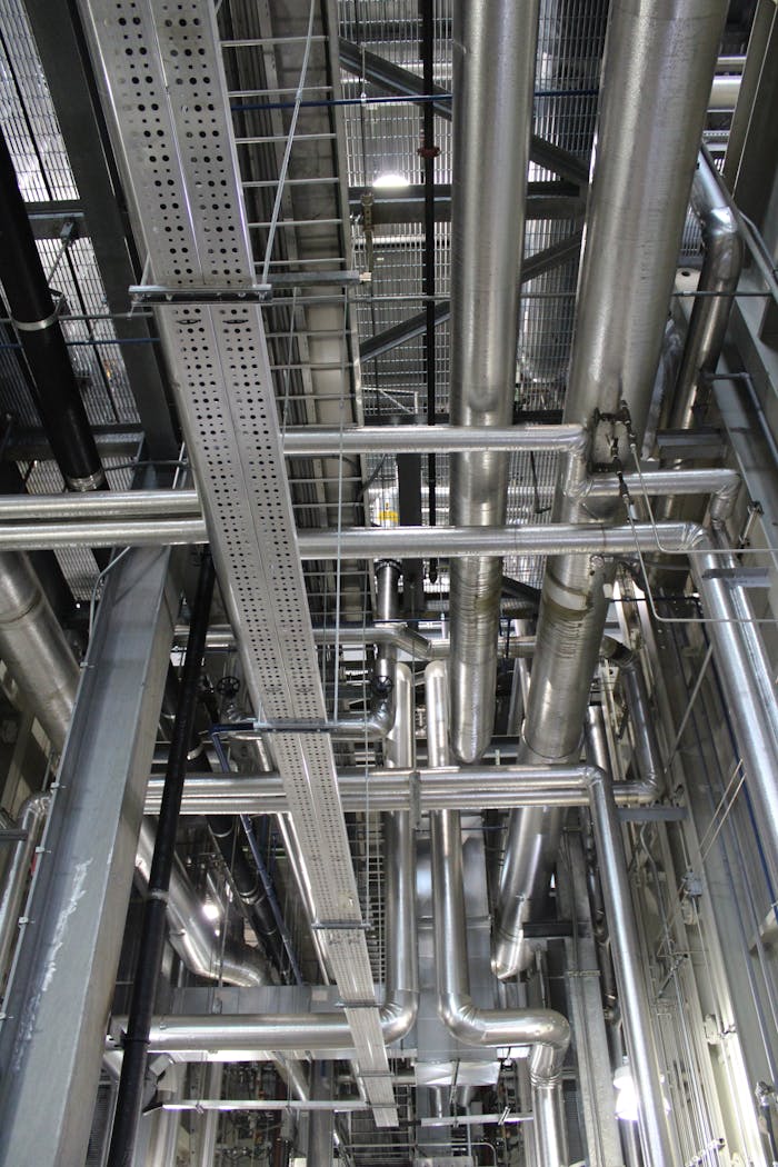 Vertical shot of steel pipes and ventilation in an industrial setting.